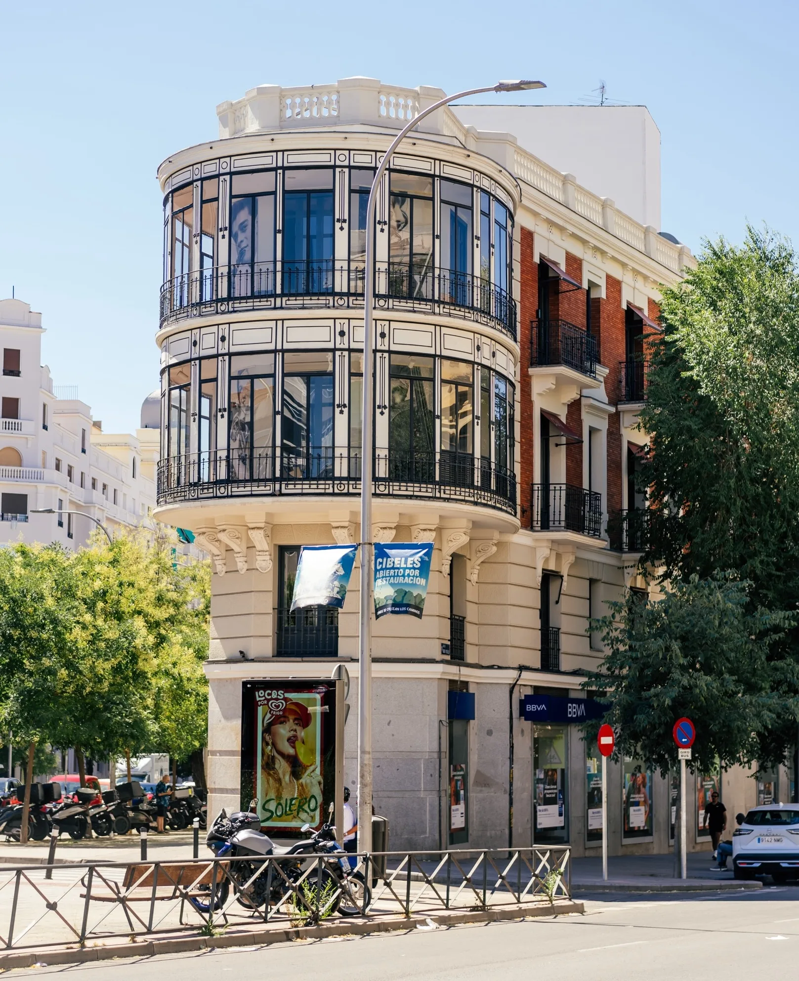 A curved glass-and-stone Art Deco corner building in Cuatro Caminos